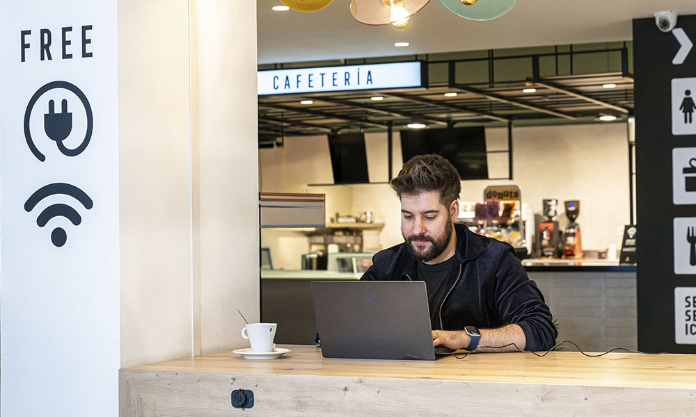 Hombre trabajando con su portatil conectado a la Wifi gratis de Abades Áreas