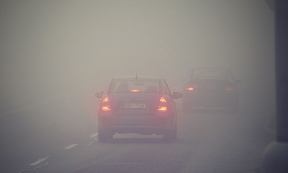 Coches conduciendo bajo una niebla espesa en la autovía