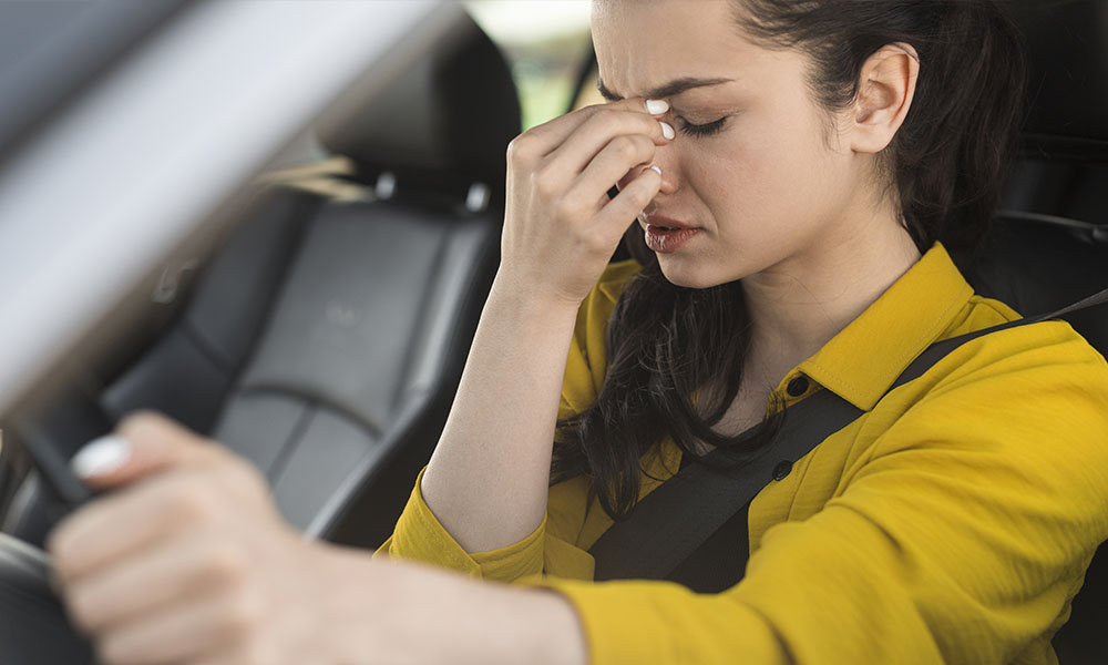 mujer conduciendo muestra fatiga al volante
