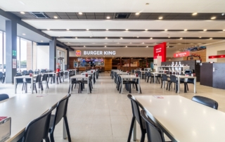 Mesas para comer en el área de servicio Abades Bailén y al fondo Burger King Bailén