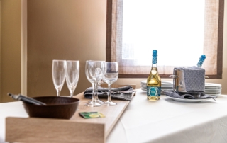 Botellas de vino con copas en salón de celebraciones de Abades Bailén