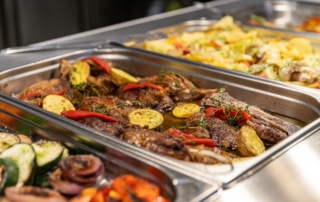 Bandejas de comida donde se aprecian verduras, carne, patatas para servirse uno mismo y comer en la autovía A2, Soria