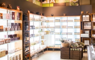 Estanterías con productos Dermo Abades don se ven jabones, cosmeticos, productos de higiene, etc.