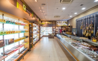 Selección de productos típicos como jamón de bellota, embutidos, aceite de oliva y mucho más en la exposición para comprar en Abades Mérida