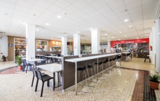 Zona de mesas alta para comer en taburete y panorámica de Abades Mérida