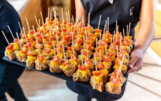Camarera sujetando bandeja de aperitivos tipo cóctel para boda en Loja, Granada