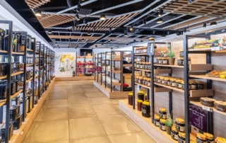 Diferentes tipos de miel, aceite de oliva y demás productos expuestos en estanterías para comprar