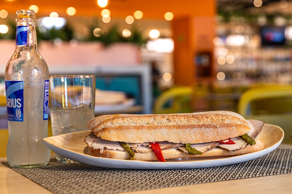 Bocadillo de lomo con pimientos asados junto a refresco Aquarius